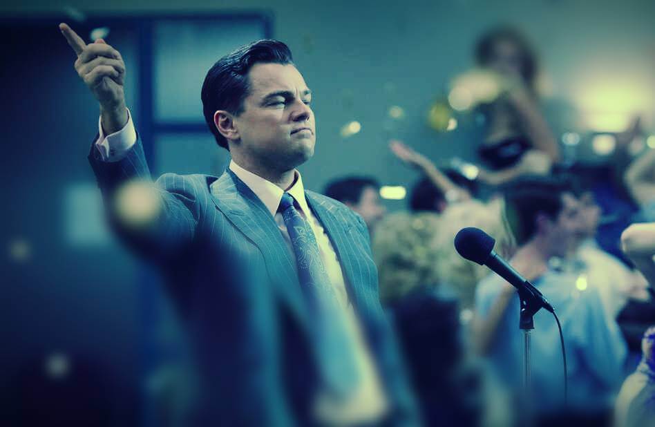 Guy in suit standing in front of floor microphone with confetti falling around him