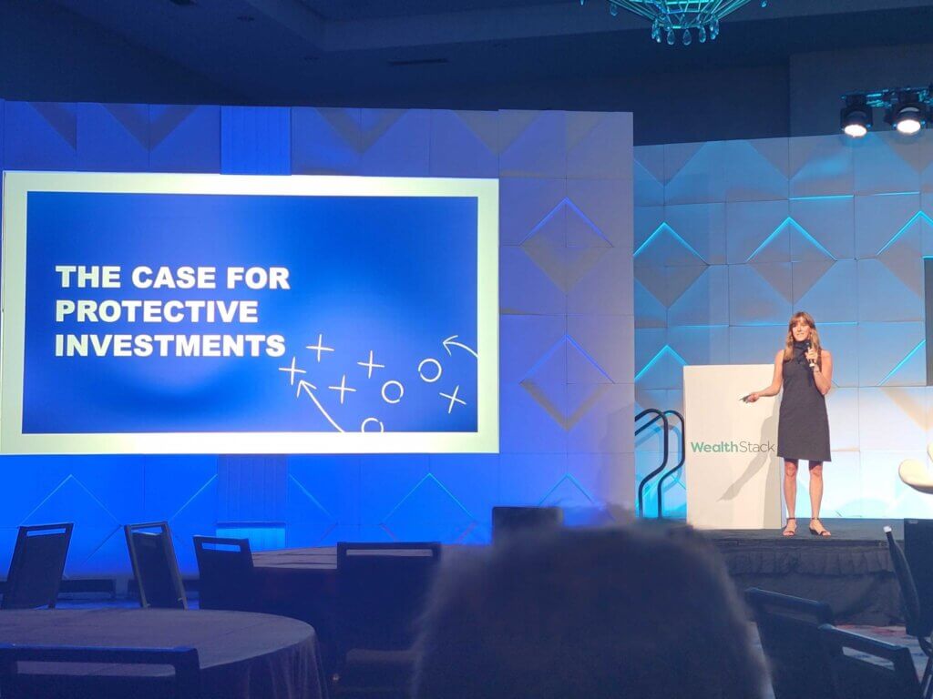 Woman standing on stage promoting the case for protective investments
