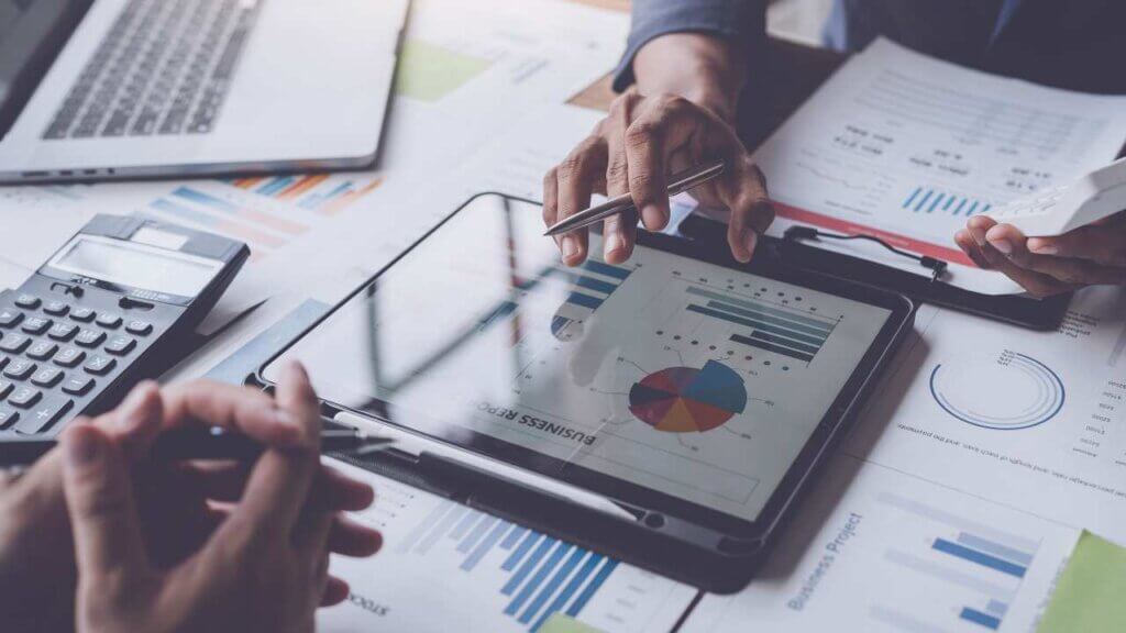 Individual talking to client with business data on tablet