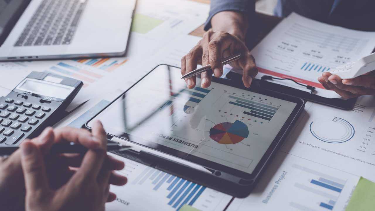 Individual talking to client with business data on tablet