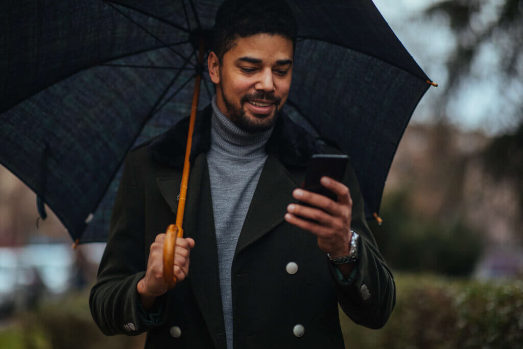 Person with umbrella looking at phone