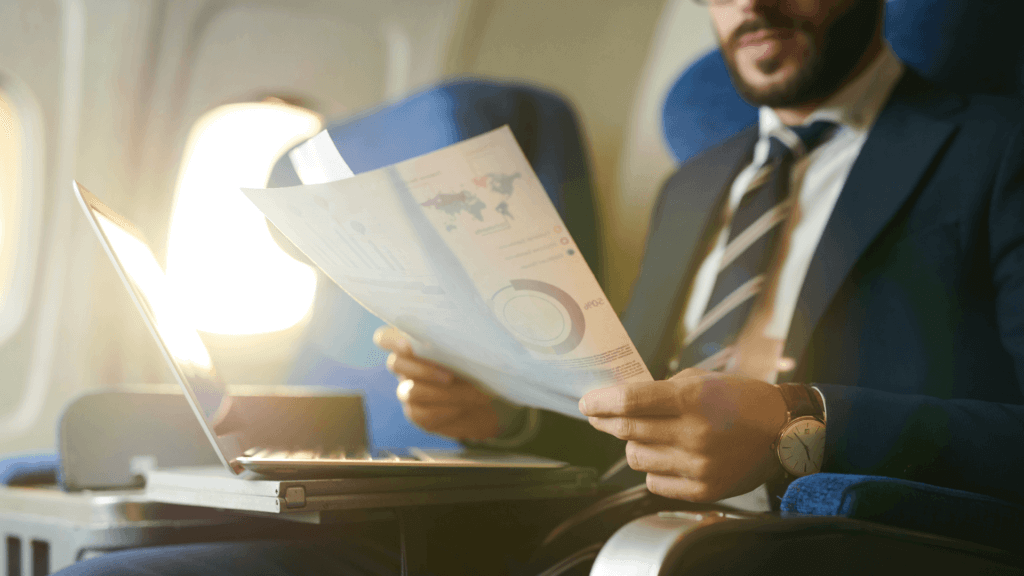 Businessman on a plane reading charts and figures